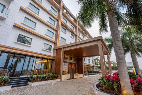 a building with palm trees in front of it at Park Inn & Suites by Radisson Bengaluru Yelahanka in Bengaluru