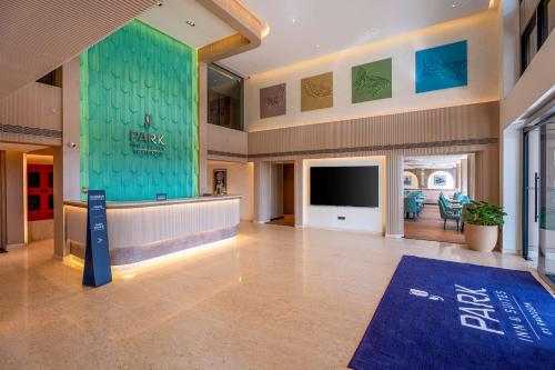 a large lobby with a flat screen tv in a building at Park Inn & Suites by Radisson Bengaluru Yelahanka in Bengaluru