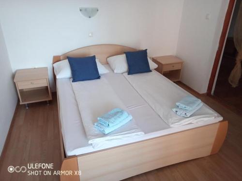 a large white bed with blue pillows on it at Room in Lopar with Balcony, WIFI 4620-96 in Lopar