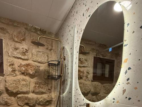 a bathroom with a mirror on a stone wall at Villa Rosa Luxury Boutique Hotel in Batroûn