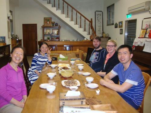 a group of people sitting around a wooden table at Taroko Sialin Coffee Farm Homestay in Xiulin