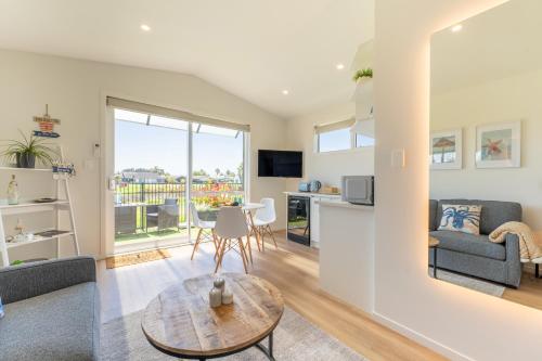 a living room with a couch and a table at Palm Springs Pearl - 7 minutes walk to the beach in Papamoa