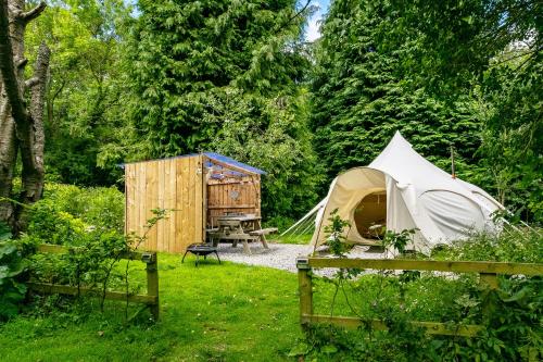 a tent and a picnic table in a garden at Alum House Littlebeck Glamping Whitby in Whitby