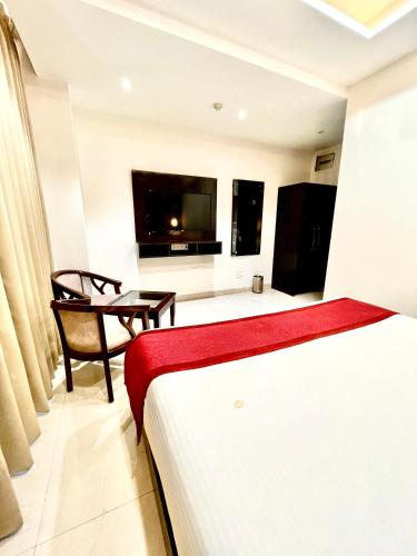 a hotel room with a bed and a television at Hotel Lycoris Zirakpur Chandigarh !! Main Highway Hotel ! Lift ! Large Parking ! Premium AC Rooms ! Traveler choice in Zirakpur