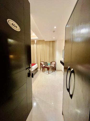 a kitchen with a refrigerator and a dining room at Hotel Lycoris Zirakpur Chandigarh !! Main Highway Hotel ! Lift ! Large Parking ! Premium AC Rooms ! Traveler choice in Zirakpur
