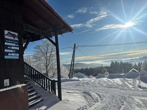 a snow covered ski slope with a ski lodge at Švarná Hanka - turistická chata in Staré Hamry