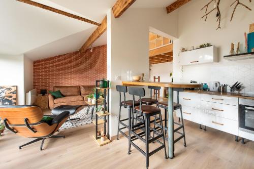 une cuisine et un salon avec une table et des chaises dans l'établissement Le Loft Botanique Et Son Parking Gratuit, à Toulouse