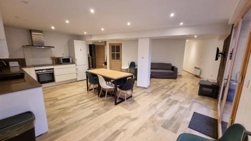 une cuisine et un salon avec une table et des chaises dans l'établissement Grand appartement Isola 2000, à Isola 2000