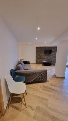 une chambre avec un lit, une chaise et un canapé dans l'établissement Grand appartement Isola 2000, à Isola 2000