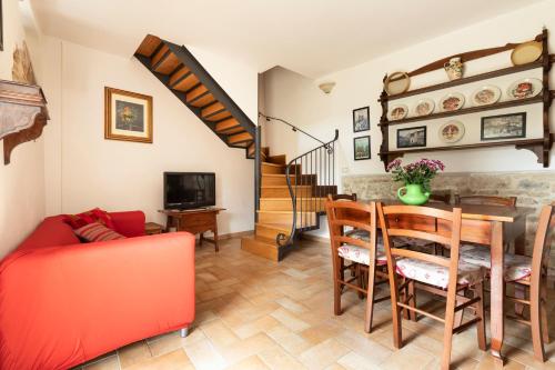 un soggiorno con un divano rosso e un tavolo di Agriturismo I Gelsi di Santa Cristina a Gubbio