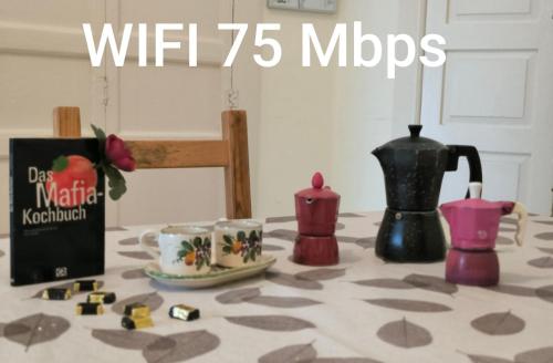 a table with a tea pot and cups on it at by Domy in Ostuni