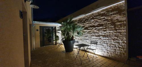 a potted plant sitting next to a brick wall at Hotel restaurant La Pêcherie - Le manoir d'à coté - Les 5 ruches -Logis hôtels in Courseulles-sur-Mer
