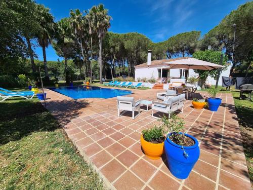 a backyard with a swimming pool with chairs and a patio at Villa Serena - Casa rural en Arcos con piscina, barbacoa, chimenea in Arcos de la Frontera