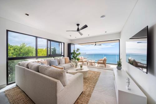 Una sala de estar con un sofá y sillas y ventanas. en Allure 501 apts, en Bridgetown