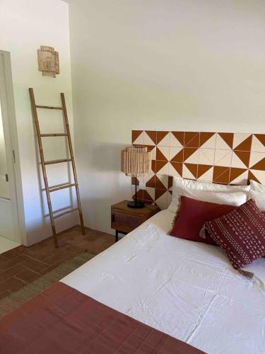 a bedroom with a bed and a ladder and a lamp at Rustic House with 2 Pools in a Monastery in Tavira