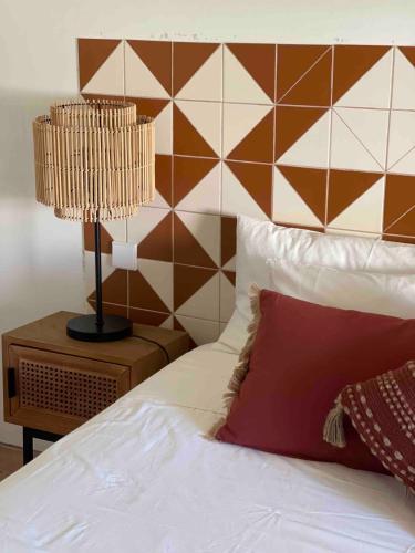 a bedroom with a bed and a lamp on a night stand at Rustic House with 2 Pools in a Monastery in Tavira