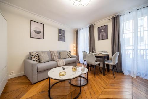 un salon avec un canapé et une table dans l'établissement CIA - rue du Colisée, near Champs Élysées, à Paris