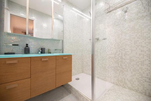 une salle de bain avec une douche avec une porte vitrée dans l'établissement CIA - rue du Colisée, near Champs Élysées, à Paris