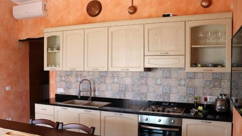 una cucina con mobili bianchi e un lavandino di Country villa Sant' Elène - Appartamento Olivo a Orosei