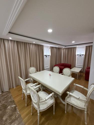 a dining room with a white table and chairs at Monelly apartments Loznica - pešačka zona in Loznica