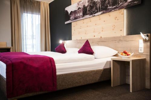 una habitación de hotel con una cama grande con sábanas moradas en Amalienburg - Boutique & Boarding Hotel, en Múnich