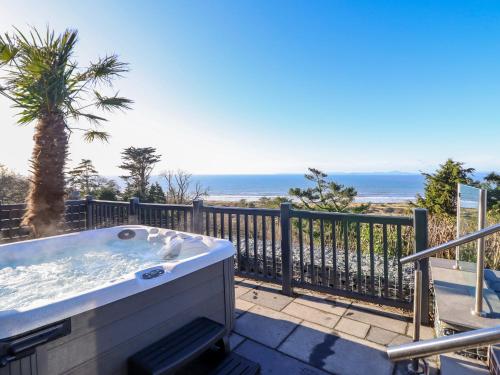 a hot tub on a balcony with the ocean at Aelfor in Harlech