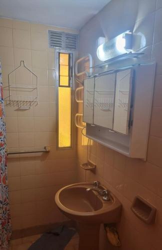 a bathroom with a sink and a mirror and a window at Duplex familiar 3 ambientes in San Bernardo