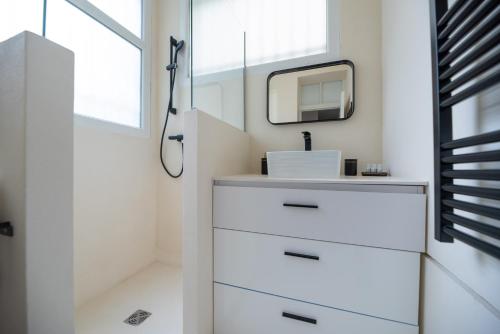 une salle de bain avec un lavabo et un miroir dans l'établissement CIA - Mezzanine Studio by Arc de Triomphe, à Paris