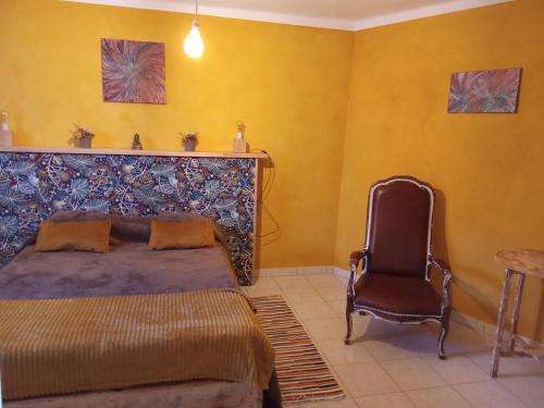 a bedroom with a bed and a chair at Casa Thocamalu's in Covelo