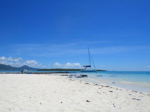 a sail boat sitting on a beach with the ocean at Villa Le Guètali in Pointe d'Esny