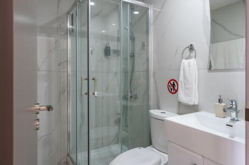 a bathroom with a shower and a toilet and a sink at Infinity - One-Bedroom Apt W Terrace in Larnaca in Larnaca