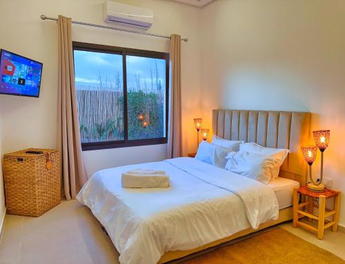 a bedroom with a large bed with a window at Villa soléa - Route Ouarzazate in Marrakesh