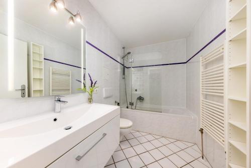 a bathroom with a sink and a tub and a toilet at Ferienwohnung Möwennest in Juliusruh