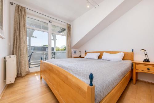 a bedroom with a large bed and a window at Ferienwohnung Möwennest in Juliusruh