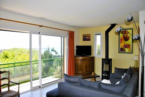 a living room with a couch and a large window at Appartement dans maison sur la Falaise in Leucate-Plage