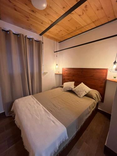 a bedroom with a large bed with a wooden headboard at El Lagar de Enzo in Icod de los Vinos