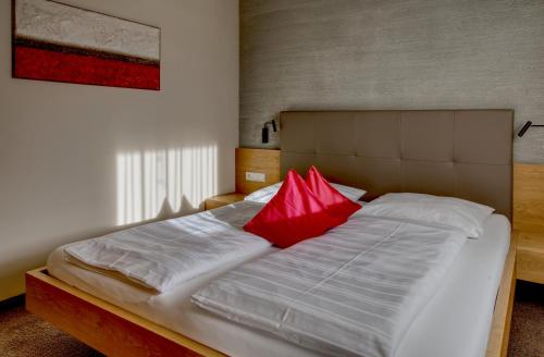 リフィアーノにあるLandhaus Freiburgerhof Wohnung 1の大型ベッド(赤い枕2つ付)