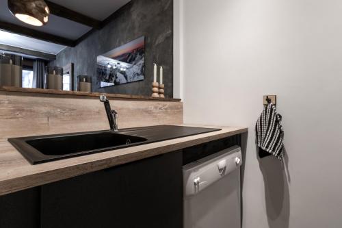 une cuisine avec un évier et un comptoir dans l'établissement Jonquille 2 - Centre - Terrasse Privee - Vues, à Chamonix-Mont-Blanc