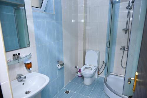 a bathroom with a toilet and a sink and a shower at Arena Hotel Qakh in Qax
