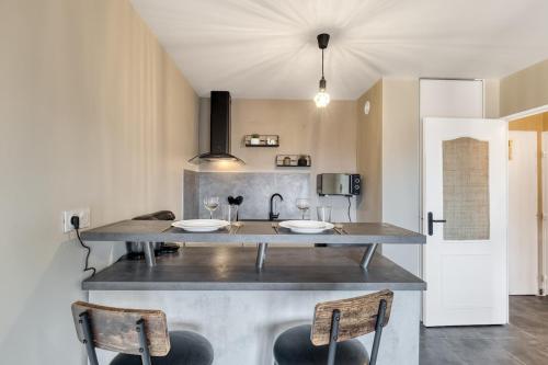 une cuisine avec deux lavabos sur un comptoir avec deux chaises dans l'établissement Le Cocon, à Thonon-les-Bains