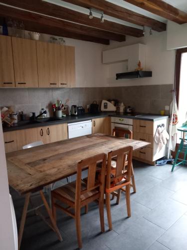 - une cuisine avec une table et des chaises en bois dans l'établissement Maison familiale dans le golfe du Morbihan, à Saint-Avé