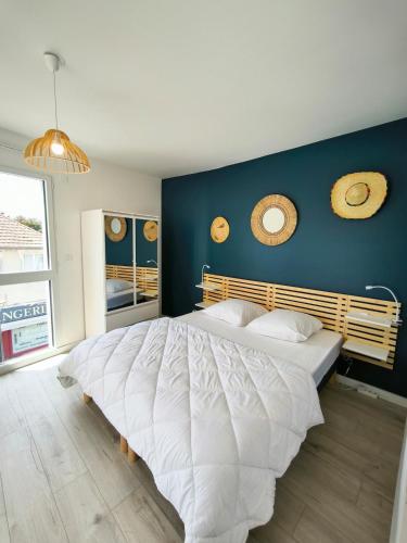 - une chambre avec un grand lit blanc et un mur bleu dans l'établissement Elégante Océan - Terrasse vue mer - Hyper centre, à Saint-Brévin-lʼOcéan