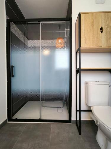 La salle de bains est pourvue d'une douche en verre et de toilettes. dans l'établissement Elégante Océan - Terrasse vue mer - Hyper centre, à Saint-Brévin-lʼOcéan