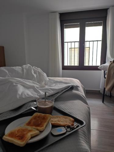 a tray with two slices of toast on a bed at La Casa de la Plaza in Castril