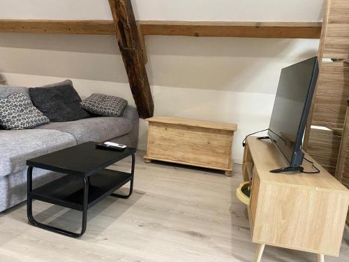 a living room with a couch and a flat screen tv at Le petit refuge in Saint-Béron