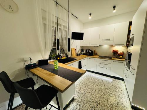 a kitchen with a wooden table and black chairs at Pineta Apartment with Exclusive Pool in Campo di Pietra
