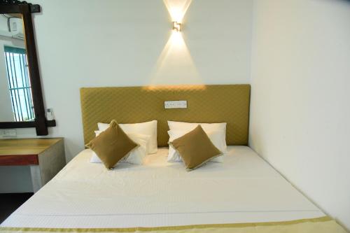 a bedroom with a bed with a light above it at Captains Cabin Hikkaduwa in Hikkaduwa