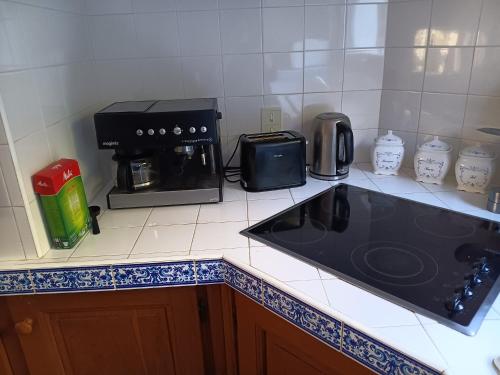 a kitchen with a black counter top with a coffee maker at Maison de campagne avec lac privé in Fendeille