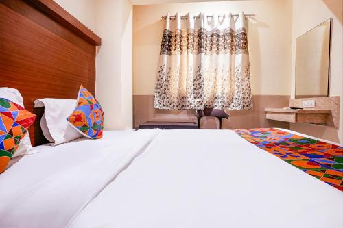 a bedroom with a large bed and a window at FabExpress Everest - Nr Vashi in Mumbai