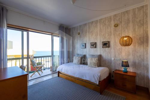 エリセイラにあるVilla du Soleil by ACasaDasCasasのベッドとバルコニーのある寝室